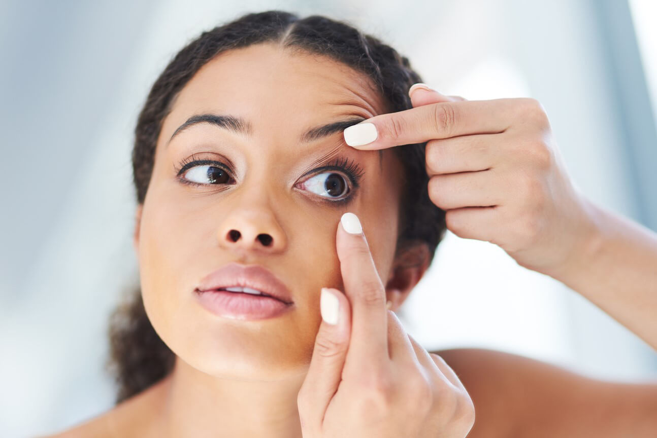 woman putting contact lens