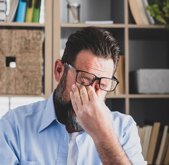 man scratching his eyes