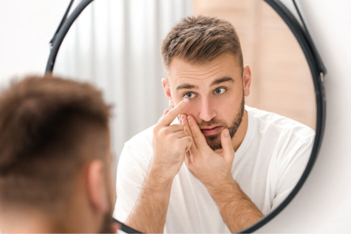 man putting contact lens